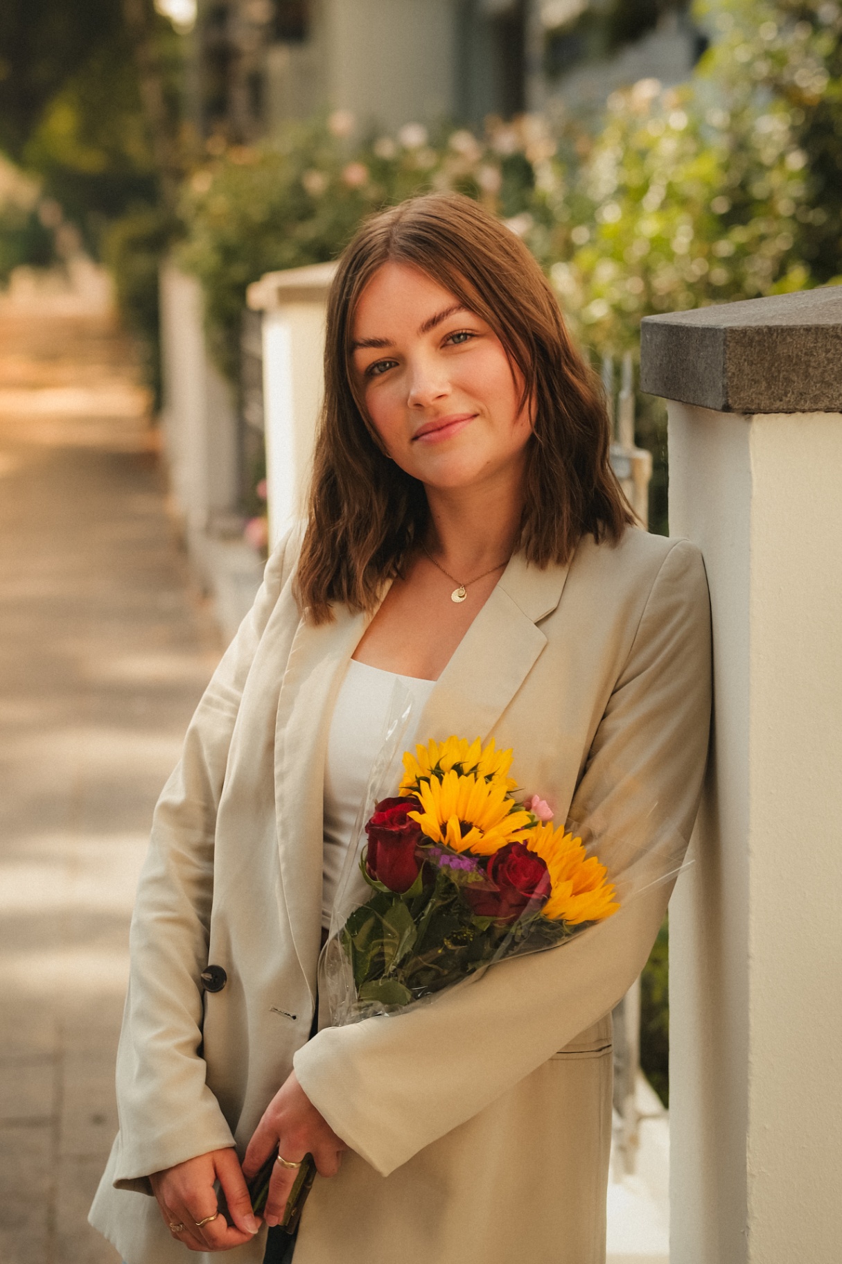 Portrait mit Sonnenblumen an einer Mauer